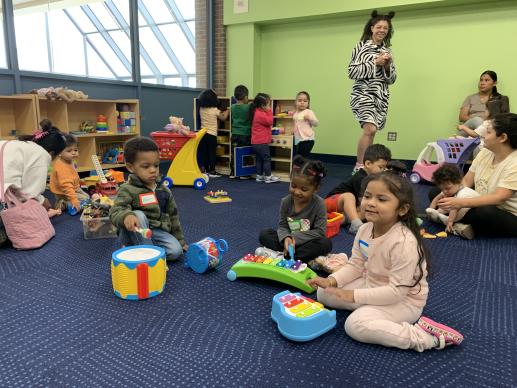 children and parents playing in library program room
