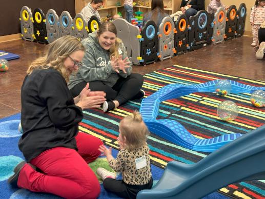 Librarian cheering on a young child mastering the skill of clapping