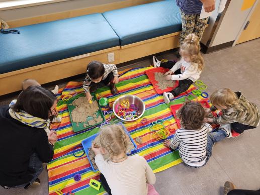 Children playing with kinetic sand together.