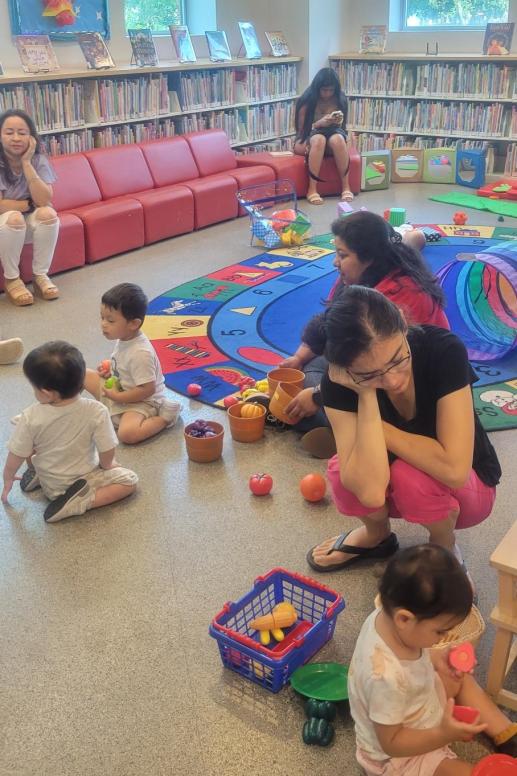 Image of children and caregivers at the library's children's area.