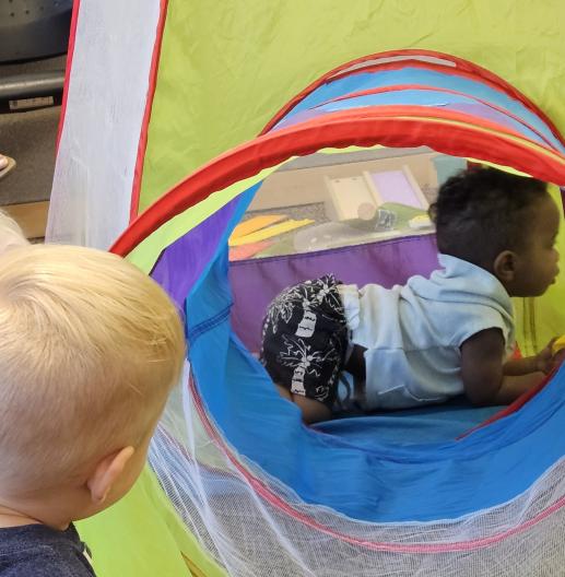 Babies play in a colorful tunnel