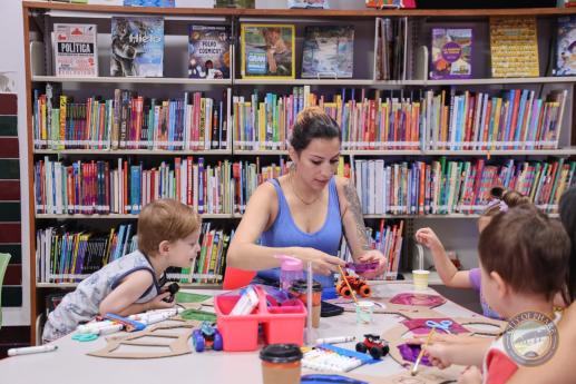 A family of three attending our Early Childhood Literacy Workshop, children and caregiver were creating dragon or butterfly wings out of cardboard, ribbon, and colorful translucent paper. The wing would later be used for imagination play.
