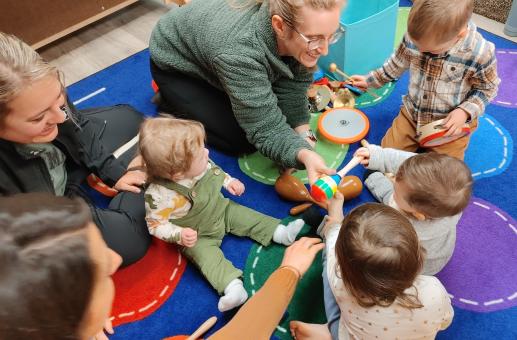 A group of children and their families exploring instruments in the music station