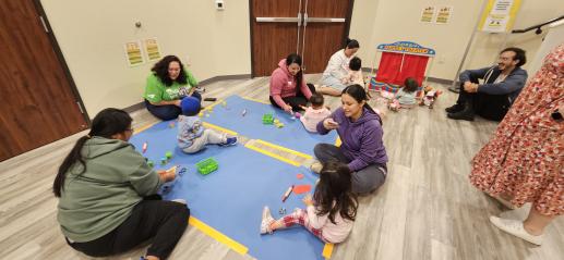 Parents and children playing with playdoh and baby dolls