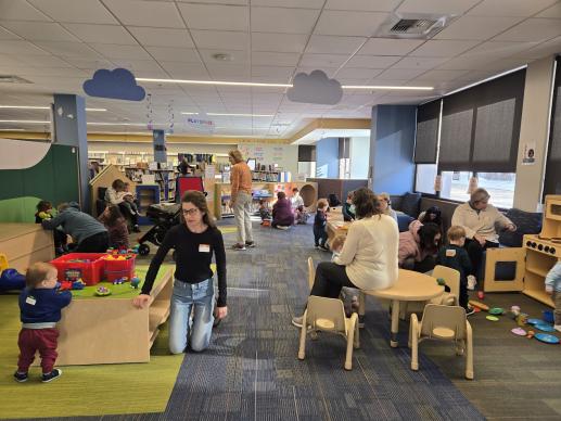 Library plat area with children and grown-ups playing at station