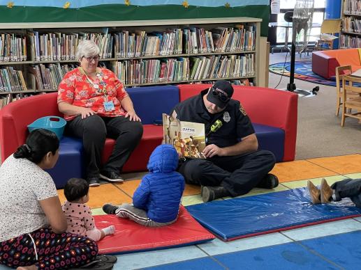 Visiting firefighters attend storytime in our 0-5 reading area.