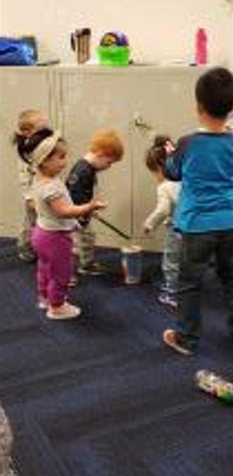 Five toddlers play with homemade drums.