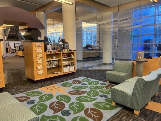 The entrance to our children's area includes a seating area with toys for children to play with, along with a book display of new books for families and caregivers to browse.  