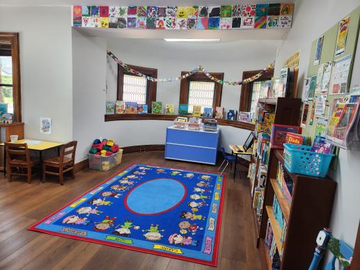 Portion of the children's room, featuring books, toy blocks, writing station, and child's play computer