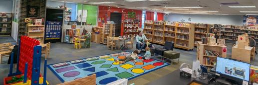 View of MPL Children's Room. Shows toys and book shelves. Colorful rug in the middle.