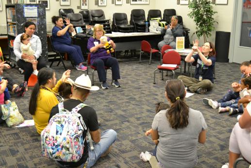 A circle of parents and children singing a song with hand motions