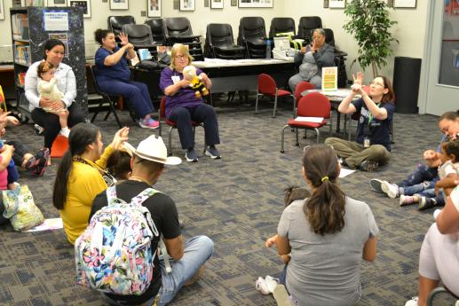 A circle of parents and children singing a song with hand motions