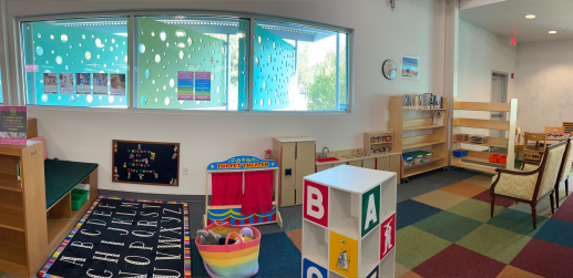 Picture of the Play Space including chalkboard, puppet theater, kitchen, parenting collection, blocks, and puzzles.