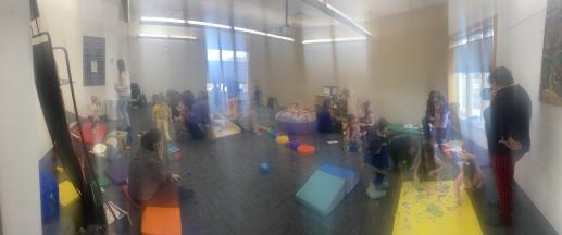 Room filled with children and adults playing.