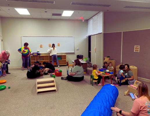 Room full of parents and children playing.