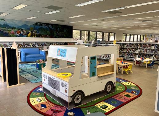 Big toy food truck on bright carpet in children's area of the library