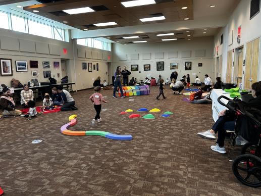 Room showing families playing with toys at different stations.
