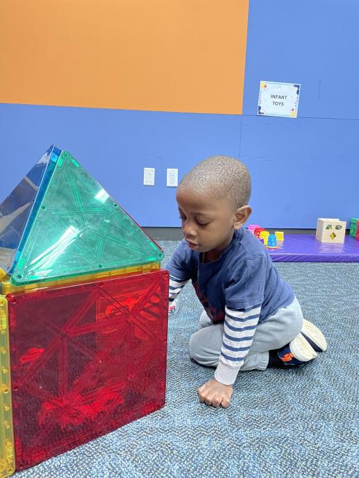 Boy playing with giant Magna-Tiles.