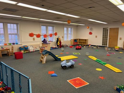 Photo shows room where the Parent Child workshop at the Greensburg Hempfield Area Library is held. It is a large room with many toys for young children.