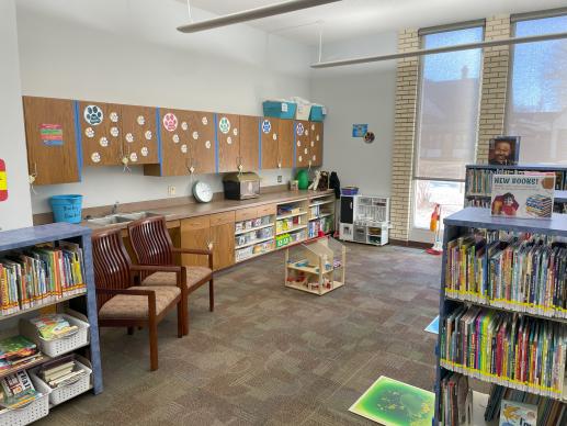Children's Room: Board Books, Spanish Books, Picture Books, toys in lower cabinets, art station.