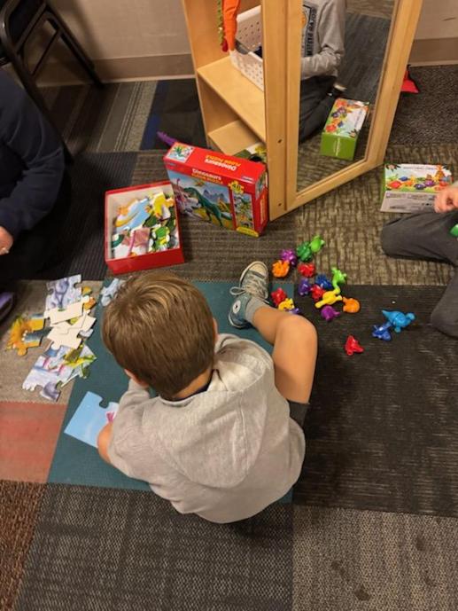 Child playing with a puzzle in Whitehall Public Library's children's room.