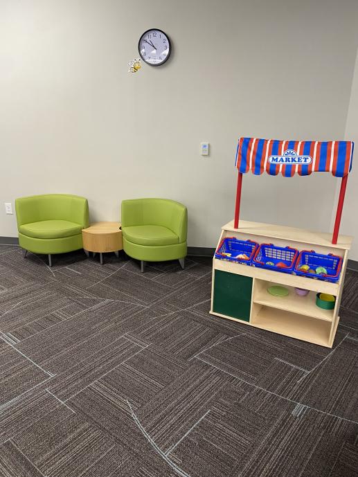 Market Toy stand and small green chairs forming a sitting area. 