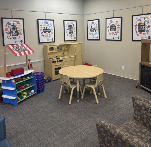 Dramatic play area with kitchen, market, puppet theater and table.