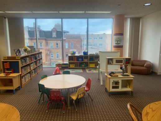 APL Family Place area showing table, board books, toys, kitchen and easel.
