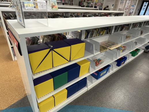 A white shelf of toys in the kids room.