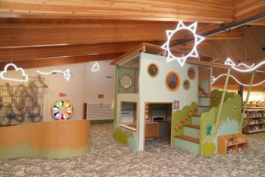 Colorful children's space with a play kitchen, toys, scarf tubes, color wheel, and illumination station. 
