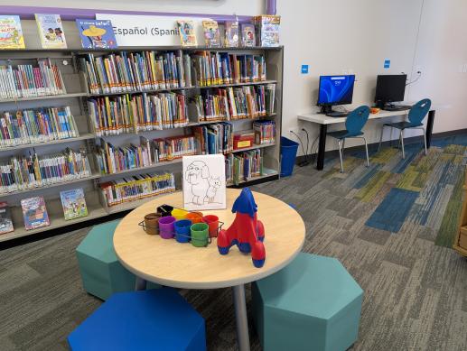 Writing table for young children including the Spanish language collection and children's computers.
