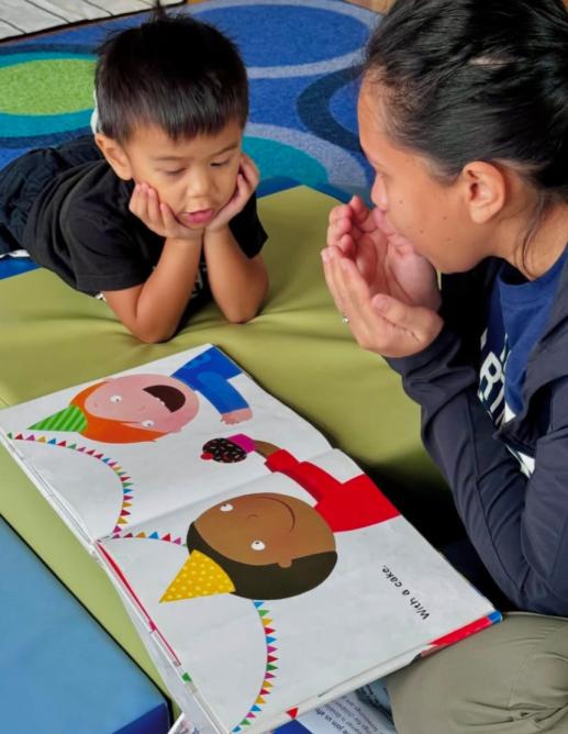 Mother and son reading a book.