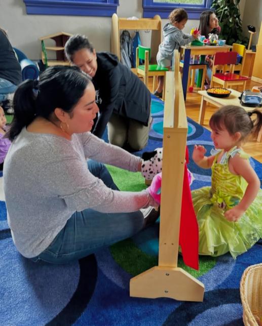 Mother and daughter playing with puppets.