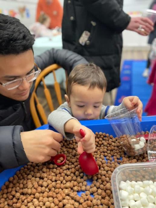 A father and son making some "hot cocoa" together. Sensory stations are the best!