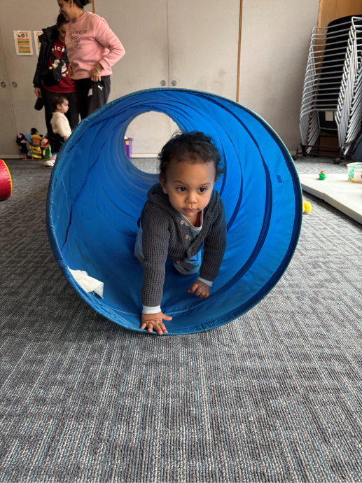 Child coming out of blue tunnel
