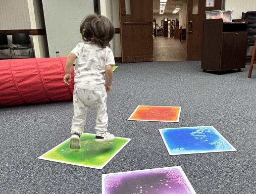 A toddler hopping on liquid floor tiles