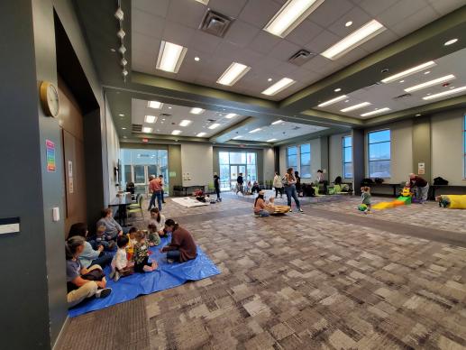 Families playing with toys, sensory bins, doodling with crayons, and creating crafts together during our Play2Learn program.