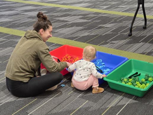 Caregiver and child enjoy sensory bins at the Smoky Hill Library Play & Learn program.