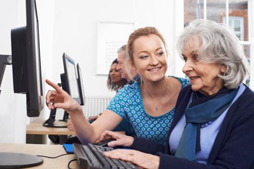 Woman helping senior at computer