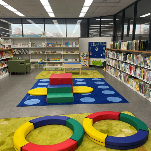 View of Children's Family Place Area. Complete with toys and picture books on shelves, children's play stairs and slide.