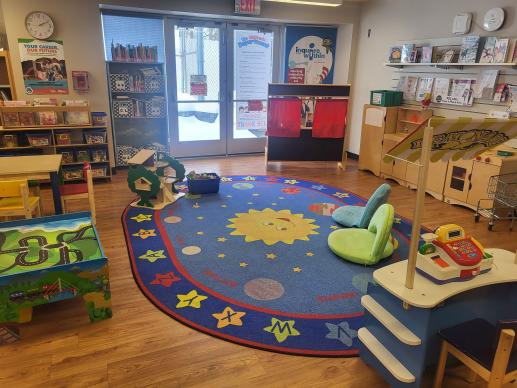An image of the Whitehall Public Library children's room with several toys, activities, and children's seating visible.