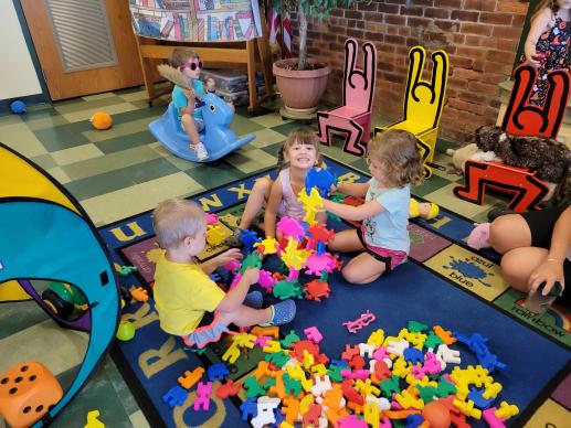 Three children play together on the floor.