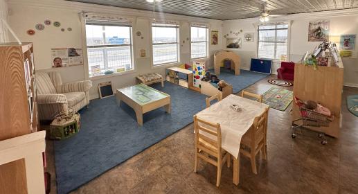 shelves of toys and books, child sized table and chairs in front