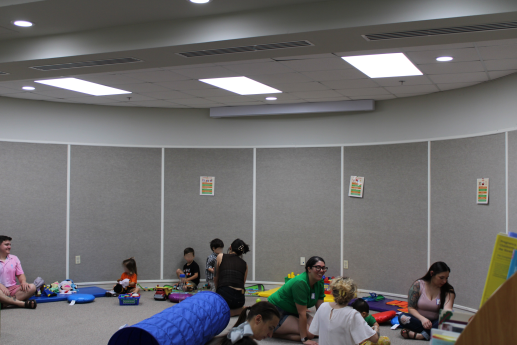 A room full of parents and children playing together with toys.