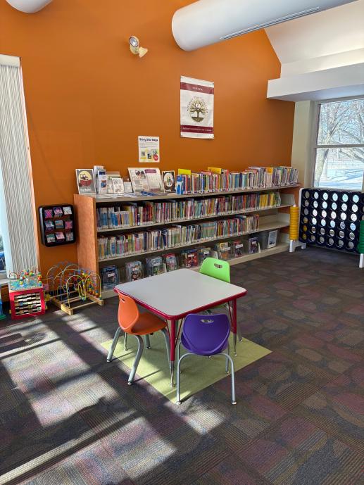 Children's bookshelf with Family Place flag hanging above.