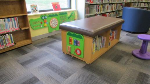 Wall toys along the floor for young toddlers and infants near the board books.