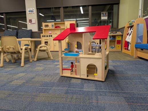 two story doll house with other play area toys behind it