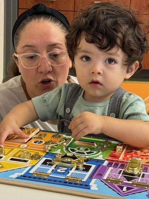 Child playing with puzzle as parents looks on.