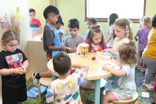 several children playing together in a play kitchen