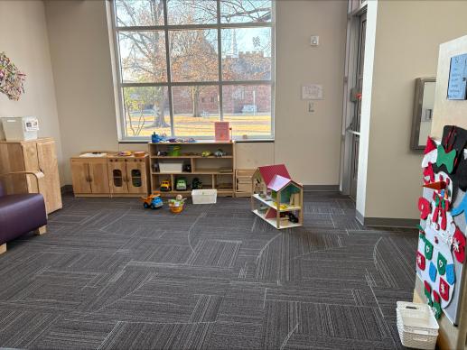 wooden kitchen, wooden doll house, felt board, and other toys in a play area